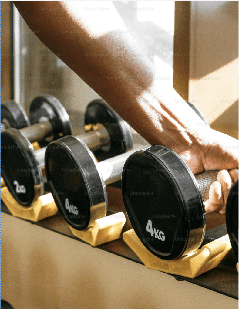 a person's arm grabbing for weights in a weight room